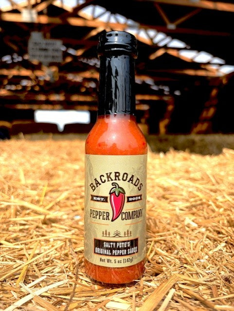 Salty Pete's Original Pepper Sauce bottle displayed on hay