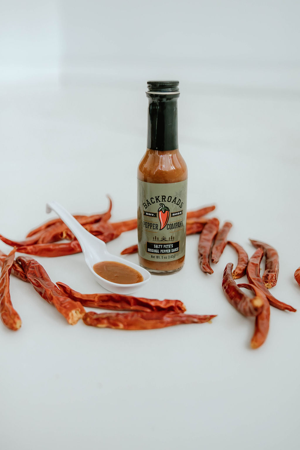 Salty Pete's Original Pepper Sauce bottle with dried cayenne peppers
